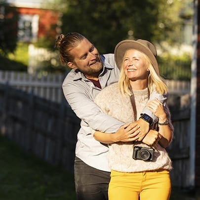 Matkailijapariskunta kameran kanssa nauttimassa ulkoiluelämyksistä