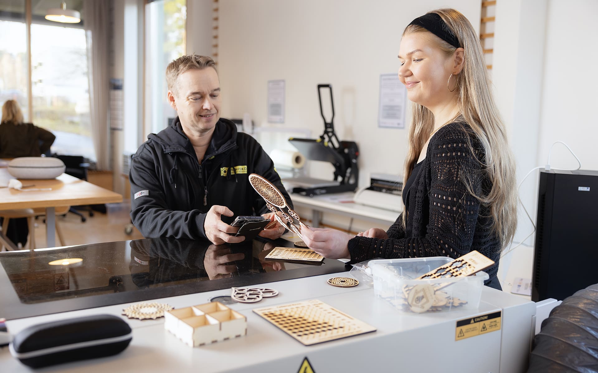 PIKES Digitupa, kuvassa kaksi henkilöä tutkii laserleikkurilla tehtyjä töitä